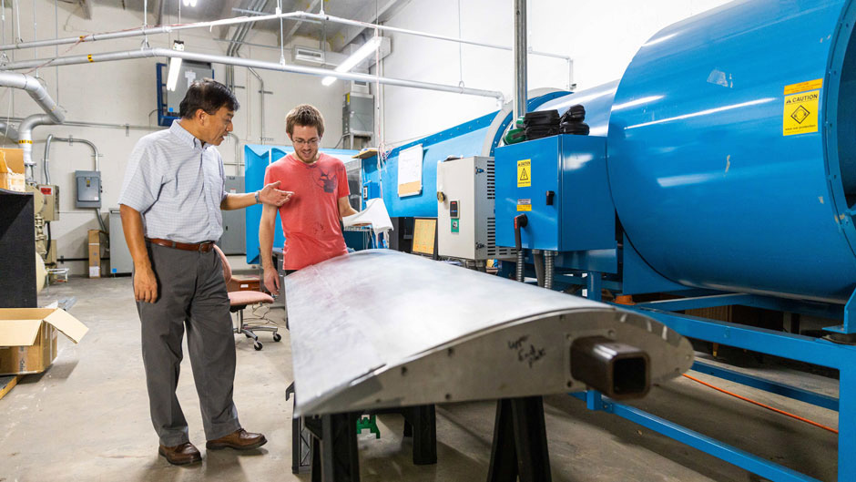 Professor GeCheng Zha and graduate student Brendan McBreen examine a prototype wing 